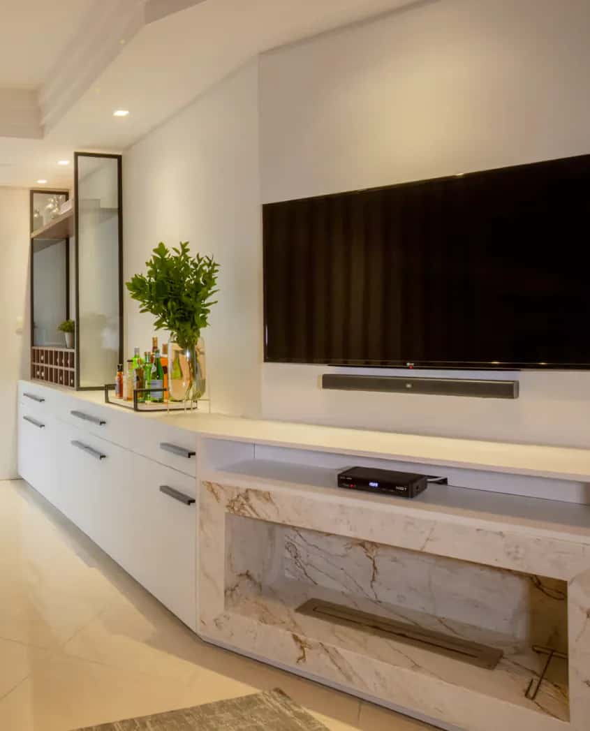 Sala com painel claro, televisão e lareira integrada